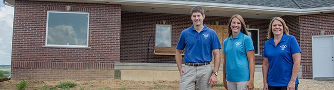 Bank employees standing in front of a house